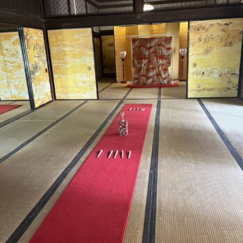 Japanese room set up for a game of Tosenkyo, fanning tossing game. With long red carpet, with the mark in the middle and fans set aside waiting for players.