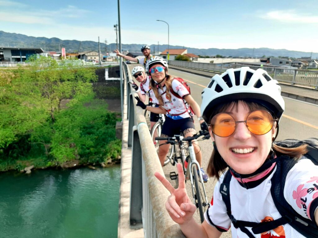 Cyclists pose on a bridge in Japan.
