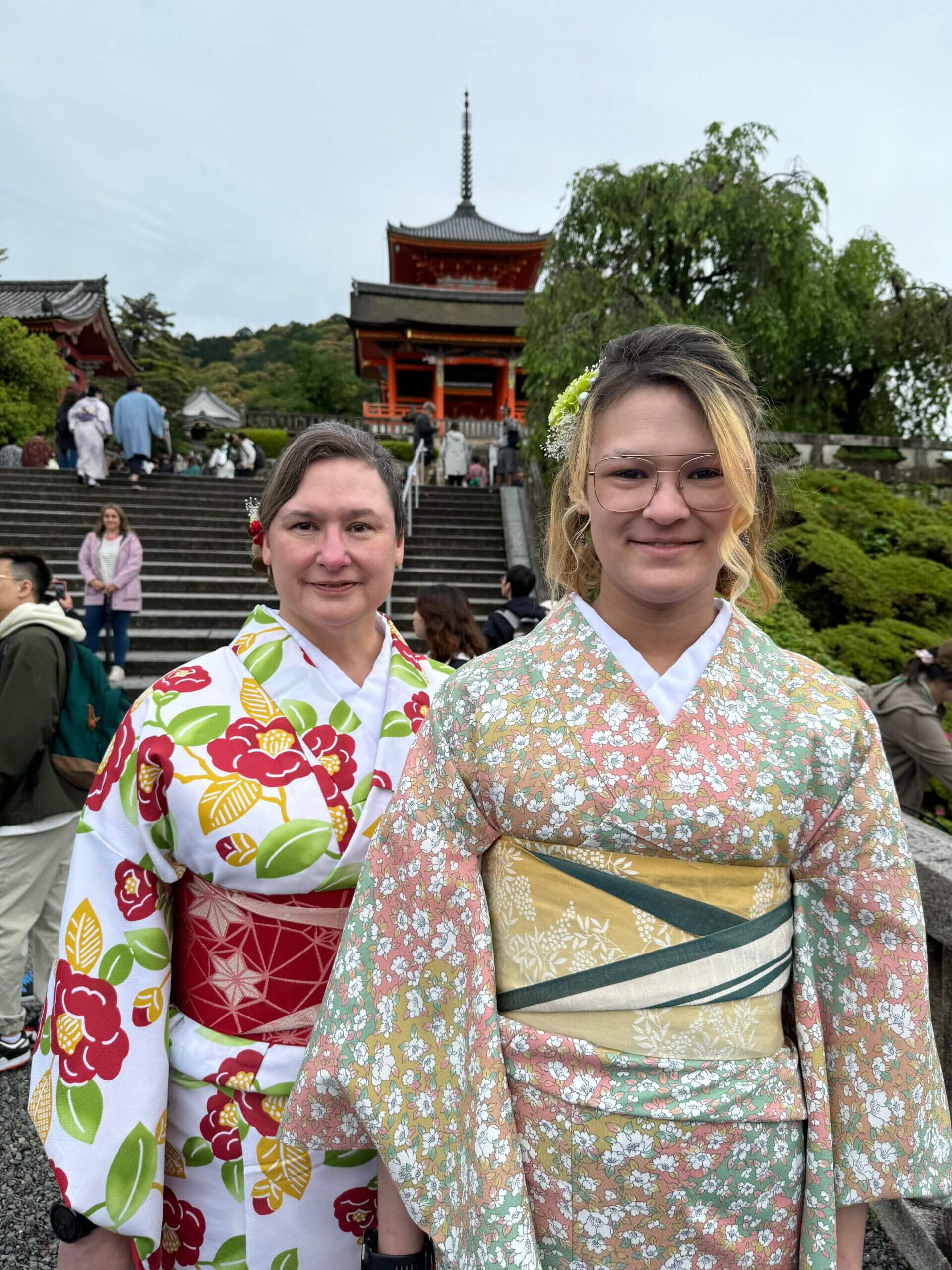 Two woman pose in beautiful colorful flower Kimonos at Kyomizu-dera in Kyoto.