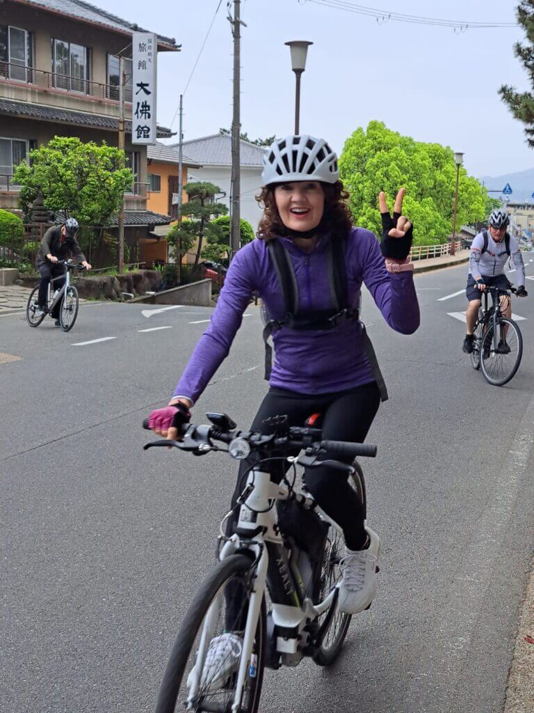 Time to ride. Woman gives peace sign as she begins riding in Nara, Japan.