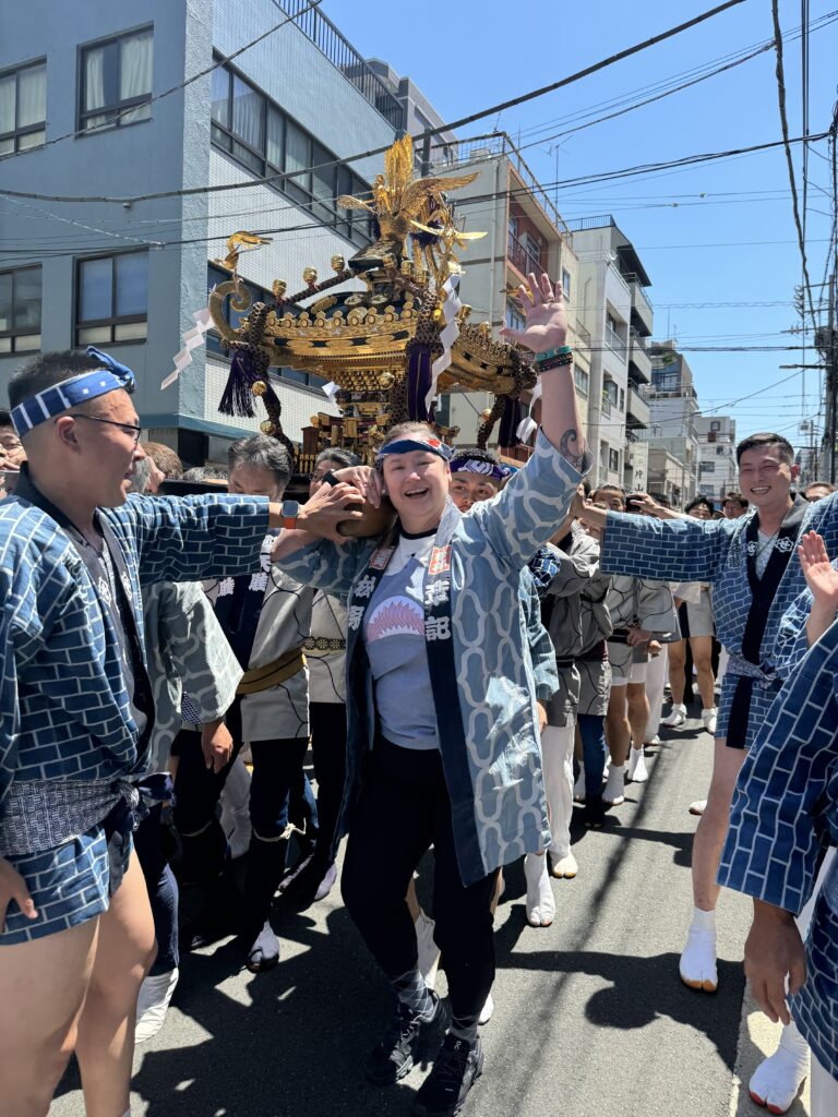 Matsuri celebration in Japan, visitor carry's golden float with other team members.