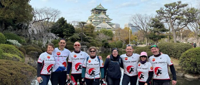 Osaka Castle with cyclists posing in the foreground