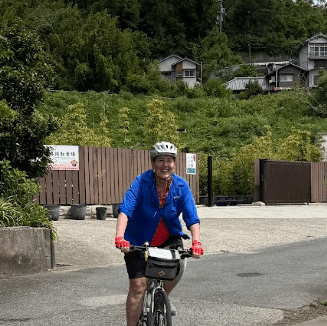 Woman enjoys cycling in rural Japan on a beautiful day with blue skies and great weather.