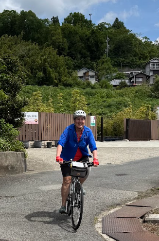 Woman enjoys cycling in rural Japan on a beautiful day with blue skies and great weather.